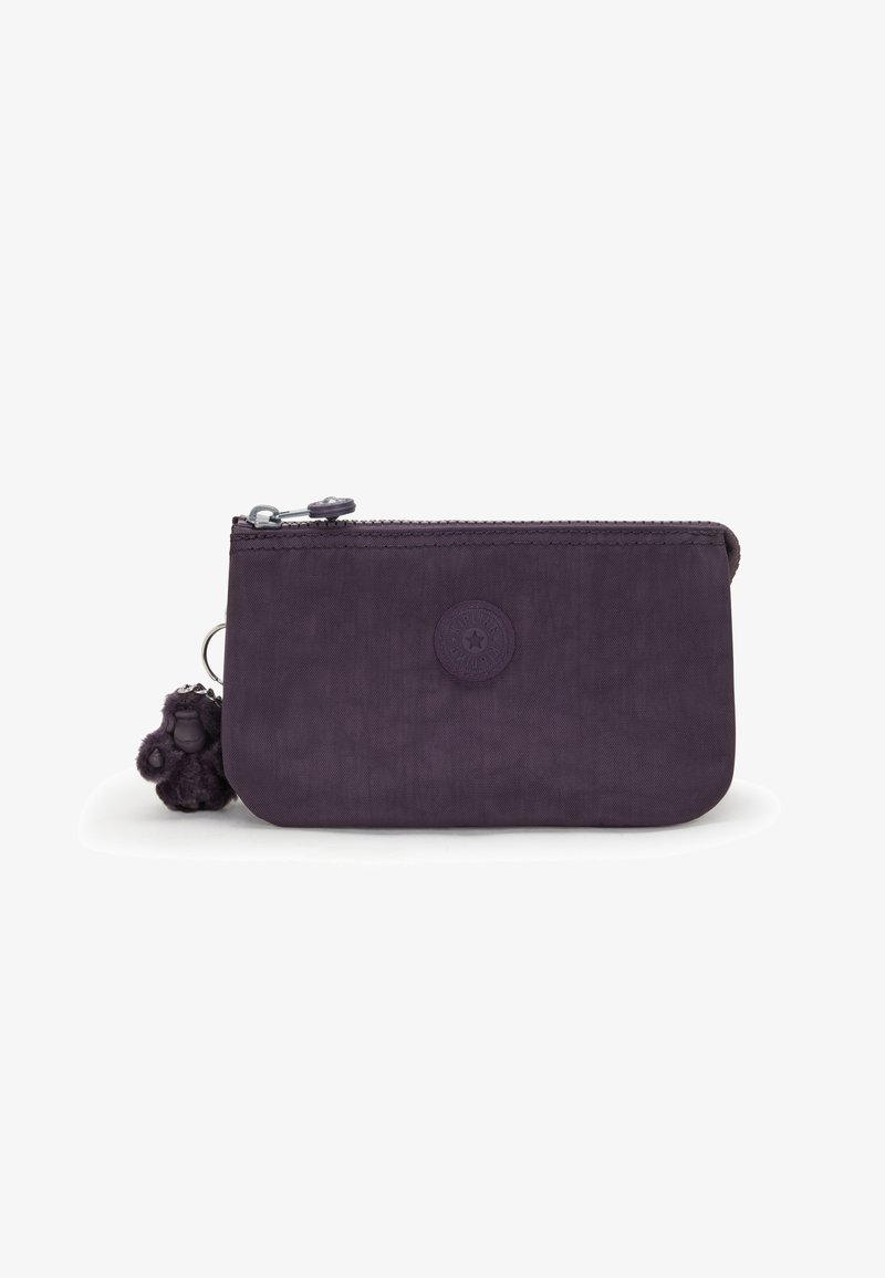 Lila Stofftasche mit einem Reißverschluss. Verfügt über ein rundes Logo und einen flauschigen Anhänger am Reißverschluss. Glatte Textur, kompaktes Design.