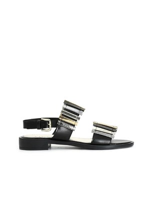 Sandali in pelle nera con suola piatta, caratterizzati da molteplici accenti a strisce metalliche sulle cinghie superiori e una cinghia alla caviglia regolabile con fibbia.