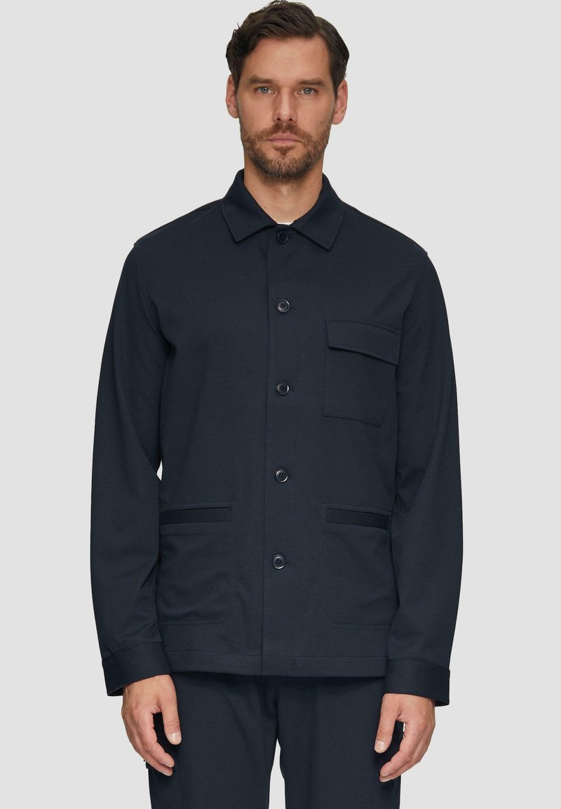 Giacca a maniche lunghe blu navy realizzata in tessuto morbido, con colletto, bottoni frontali, una tasca sul petto e due tasche laterali.