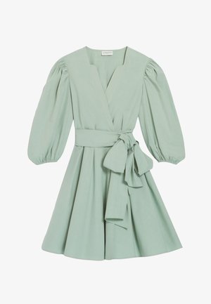 Hele rohelise tooniga ülikond, millel on siledast kangast puff-sleedid, kinnitatud vöökoht ja laienev seelik. V-kujuline kaelus ja põlveni ulatuv lõige.