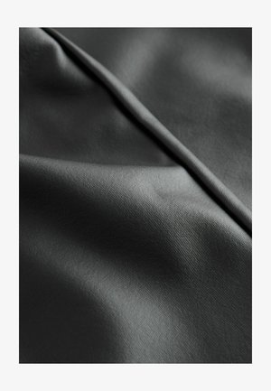 Juodas sintetiniai audinys su lygiu paviršiumi, kuriame yra subtilus blizgesys ir sulankstyti sluoksniai, pabrėžiantys jo lanksčias ir patvarias savybes.