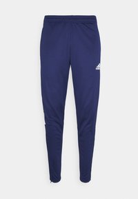 Marineblauwe sportbroek met een taps toelopende pasvorm, elastische tailleband en ritssluitingen bij de enkels. Bevat een wit merklogo op de linkerheup.