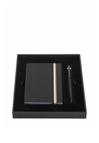 Cahier noir avec des rayures verticales blanches et beige, accompagné d'un stylo noir assorti, le tout présenté dans une boîte cadeau noire avec insert moulé.