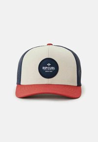 Baseball cap with a cream front, navy mesh sides, and a red visor. Features a circular logo patch in navy with white lettering.