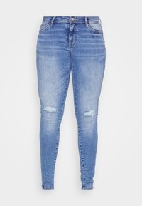 Jeans skinny de cor azul clara feitos de denim, com detalhes desgastados nos joelhos e um design clássico de cinco bolsos. Cintura padrão com fecho de botão.