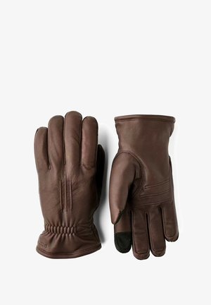 Brune læderhandsker med en glat tekstur, tre sømme på hver finger og en rynket håndled for en tæt pasform. En finger har en sort spids.