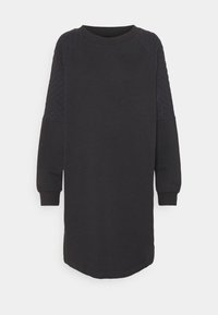 Svart sweatshirtklänning av mjukt tyg, med kviltade svarta ärmar, långa ärmar och rundad nederkant för en avslappnad passform.