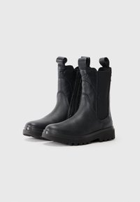 Botas de tobillo negras de cuero con paneles elásticos en los laterales y una cremallera visible. Suela resistente con ranuras para tracción. Lengüetas en la parte superior.
