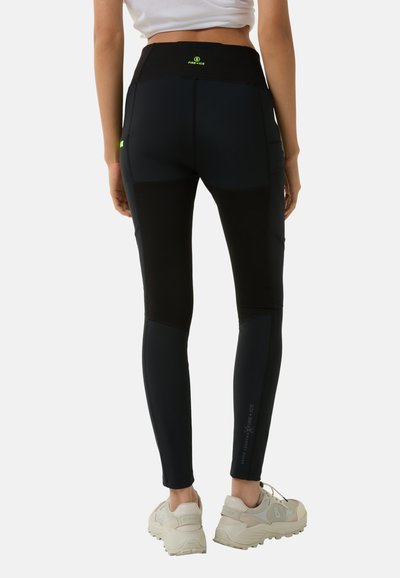Schwarze Leggings mit kontrastierenden dunklen Einsätzen, hoher Taille und reflektierenden Akzenten. Hergestellt aus dehnbarem Material, das für Bewegung ausgelegt ist.
