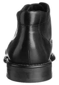 Stivale alla caviglia in pelle nera con texture liscia, tacco arrotondato e dettagli di cucitura. La parte posteriore presenta una leggera curvatura verso l'alto al colletto.