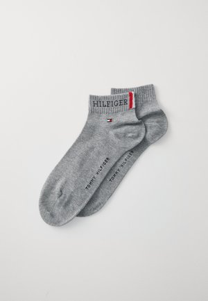 Grå bomullsstumpor med ribbade manschetter, som har broderad text "HILFIGER" och en liten detalj med röd och blå logga.