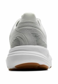 Scarpa da ginnastica bianca con una tomaia testurizzata e strisce orizzontali nere, suola bianca imbottita e suola in gomma marrone.