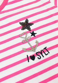 Gestreepte T-shirt in roze en wit met een glinsterende zwarte ster, geborduurde zilveren anker en de tekst "I ♥ SYLT" in zwart.