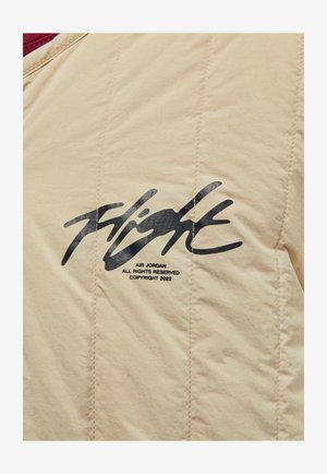 Beige quiltet jakke med en bordeaux krave. Sort "Flight" logo med brandingdetaljer trykt på brystet. Struktureret stoffinish.