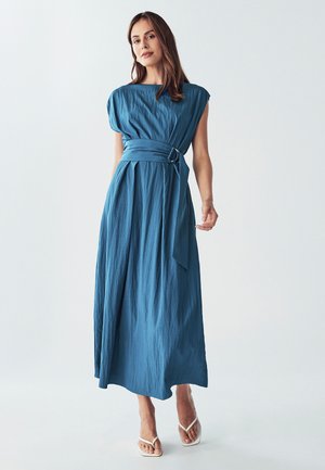 Blaues Maxikleid mit strukturierter Oberfläche. Verfügt über kurze Kappenärmel, einen Gürtel mit rundem Schnallenverschluss und eine fließende Silhouette. Geschlossene Sandalen.