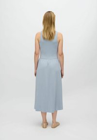 Jasnoniebieska, bezrękawnikowa sukienka maxi z ściągniętym w pasie fasonem, zwiewnym dołem i gładką teksturą. Prosty krój bez widocznych wzorów ani akcentów.