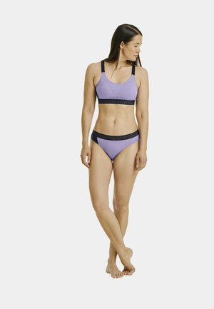 Lila Bikini-Set mit einem Sport-BH mit dicken schwarzen Trägern und passendem Unterteil. Der Bund hat ein Logomuster. Glatte Stoffoberfläche.