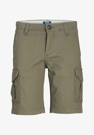 Chłopiec w niebieskiej koszulce Jack & Jones, oliwkowych spodniach typu cargo, czarnych skarpetkach i białych trampkach, stoi z jedną ręką w kieszeni.