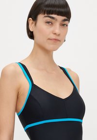 Costume da bagno nero con spalline e dettagli azzurri, design con scollo a V e costruzione senza cuciture per un aspetto elegante.