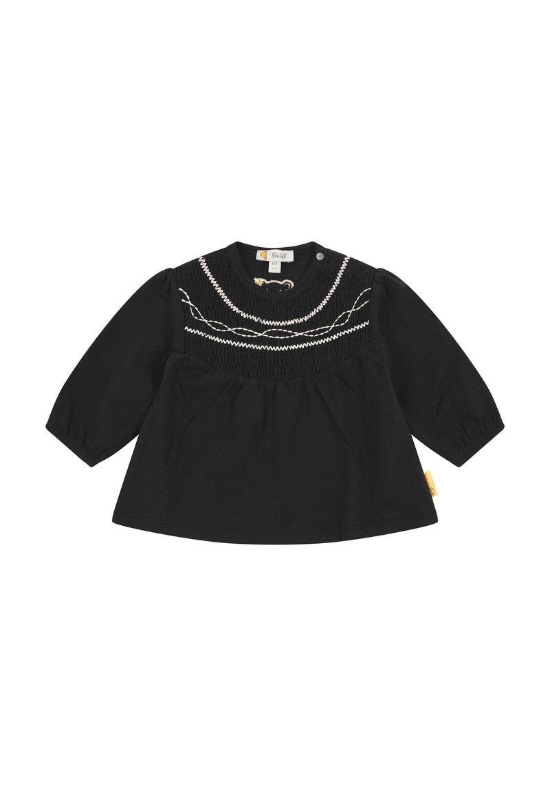 Top nero a maniche lunghe con corpetto arricciato, dettagli ricamati bianchi e chiusura a pressione sul collo. Realizzato in tessuto morbido.