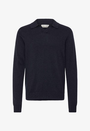 Tumši zils pulovers ar V veida izgriezumu un īsu apkakli. Izgatavots no mīksta auduma, ar garām piedurknēm un ribotām aprocēm un apakšmalu.