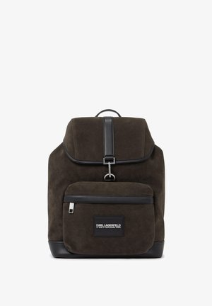 Tumepruun seemisnahast seljakott musta nahast ääristusega, esiküljel tõmblukuga tasku, metallist pandla sulgur ning Karl Lagerfeldi logoga plaastriga taskul.