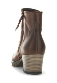 Brown leather ankle boot with a side zipper, tapered shape, and a stacked heel featuring horizontal ridges for texture.