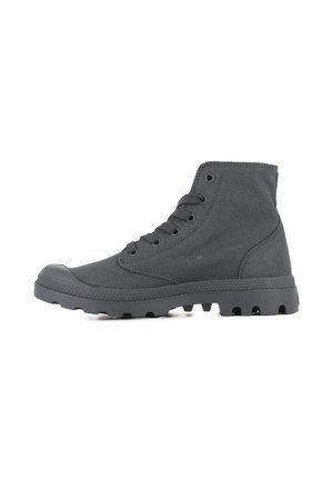Black high-top shoe made of canvas, featuring rubber toe cap, lace-up design, and patterned sole with traction studs.