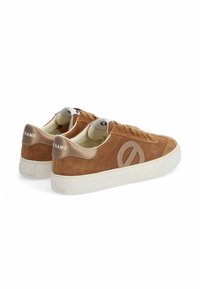 Brown suede low-top sneakers with a white rubber sole, featuring decorative stitching and a circular logo on the side. Accented heel detail.