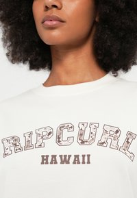 Witte katoenen T-shirt met een opvallende bruine bloemenpatroon "RIPCURL"-grafiek en de tekst "HAWAII" eronder, met een klassieke ronde halslijn.