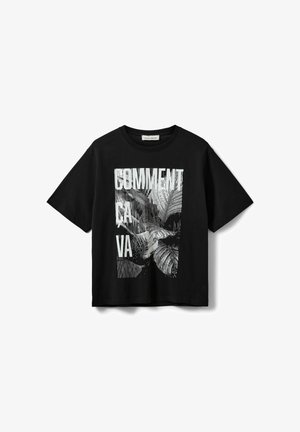 T-shirt noir à manches courtes avec un motif vertical blanc d'un visage de chat et le texte "COMMENT CA VA" sur le devant.