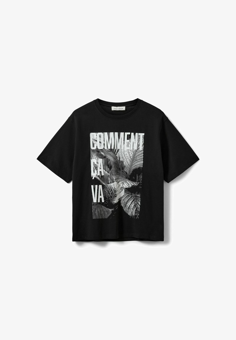 T-shirt noir à manches courtes avec un motif vertical blanc d'un visage de chat et le texte "COMMENT CA VA" sur le devant.