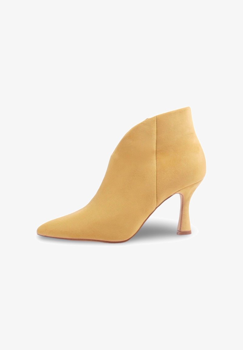 Botte de cheville en daim jaune avec un bout pointu et un talon courbé, présentant une texture lisse et une silhouette élégante.