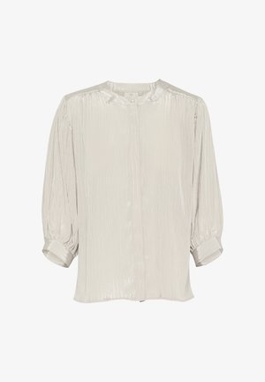 Blouse gris clair en tissu texturé. Dotée d'un col rond, d'une fermeture à boutons et de manches bouffantes 3/4 avec détails de poignet.