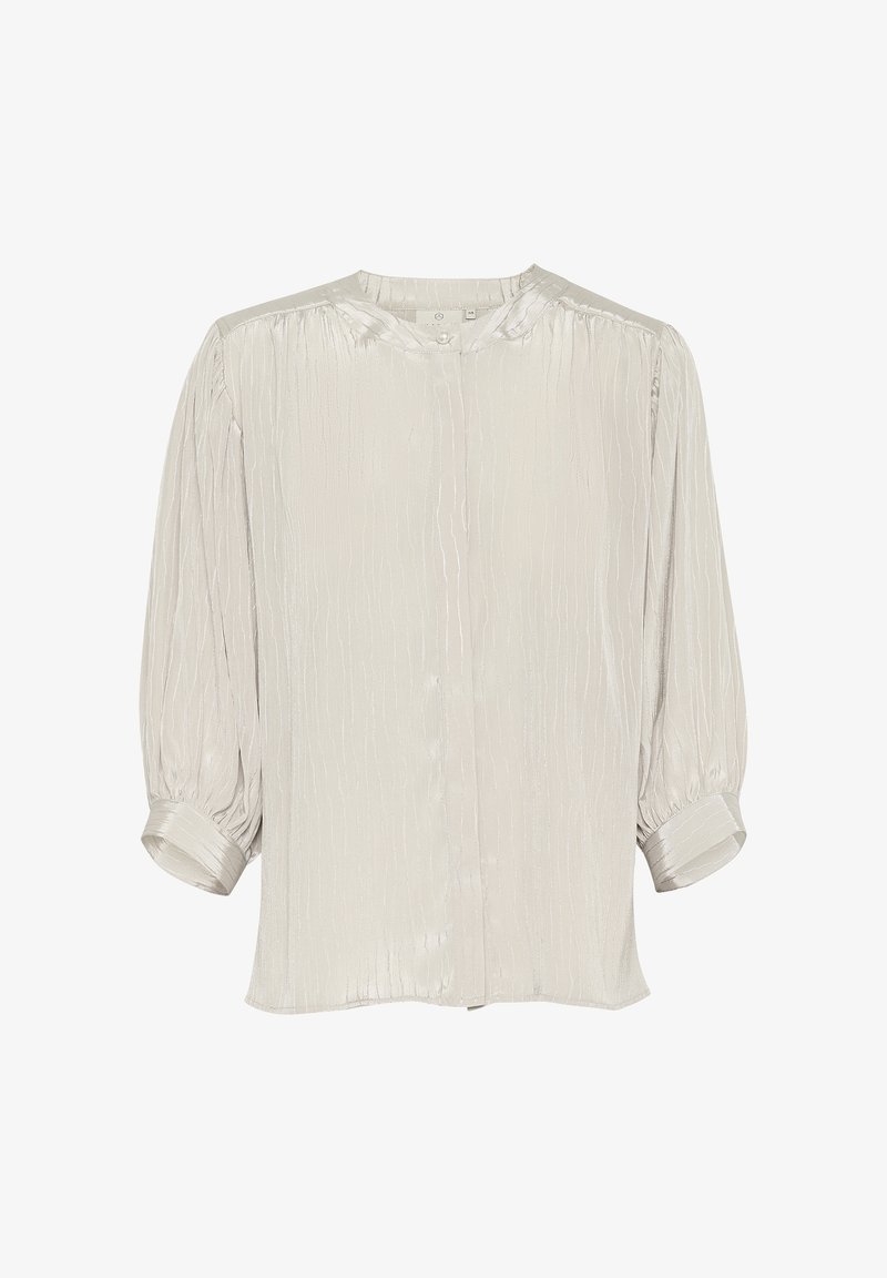 Blouse gris clair en tissu texturé. Dotée d'un col rond, d'une fermeture à boutons et de manches bouffantes 3/4 avec détails de poignet.