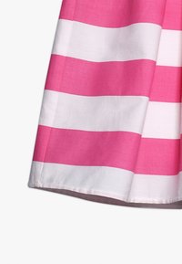 Tejido a rayas con franjas horizontales alternas en rosa y blanco. Textura suave, costuras visibles en el dobladillo y un diseño casual.