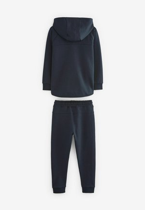 Granatowy sweatshirt z kapturem oraz pasującymi spodniami dresowymi. Wykonany z miękkiego materiału, posiada elastyczne mankiety i luźny krój.