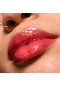 Glanzende lipgloss op volle, roze lippen met een subtiele glinsterende textuur. Close-up van de lippen die een gladde, glanzende afwerking en een natuurlijke huidtint tonen.