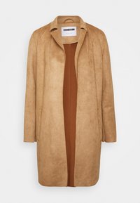 Tan mockasinfodral med avslappnad passform, öppen front och utan knäppningar. Har två sidofickor och en slät brun innerfoder.