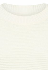 Nærbillede af en hvid strikket sweater, der viser ribbet krave og tekstureret strikkemønster på stoffet.