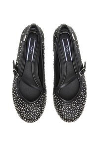 Chaussures plates noires avec un bout arrondi et un design clouté. Cuir lisse avec une sangle décorative et des clous argentés sur toute la surface.
