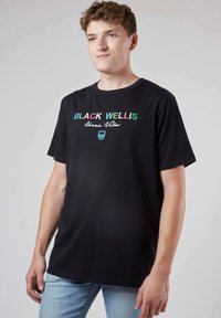 T-shirt en coton noir avec texte brodé multicolore, manches courtes et col rond. Design simple avec une coupe décontractée.