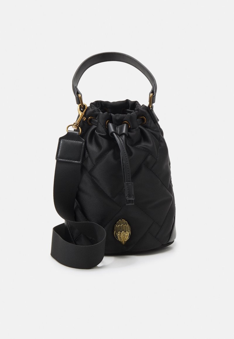 Černá prošívaná nylonová kabela ve tvaru kbelíku s dotahovacím uzávěrem, krátkým uchem a dlouhým nastavitelným popruhem. Obsahuje zlatý logový akcent.