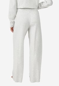 Lichtgrijze sweatpants gemaakt van zacht materiaal, met een relaxte pasvorm, elastische tailleband en een achterzak met een minimalistisch ontwerp.