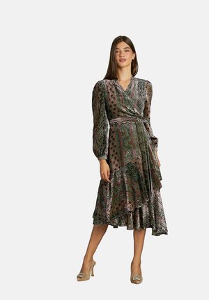 Vestido envolvente de patrón verde y rosa con mangas largas, falda acampanada y cintura ajustada, que presenta una mezcla de texturas y diseños intrincados.