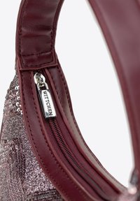 Bordeauxleren handtas met een ritssluiting en metallic pailletten aan de buitenkant. Inclusief een zilveren WITTCHEN-tag aan de ritssluiting.
