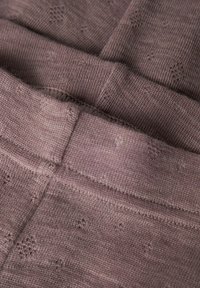 Tissu tricoté dans une nuance de mauve doux, avec de petits motifs texturés et une taille plate. Le matériau semble doux et légèrement extensible.
