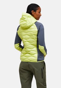 Letvægts hættejakke med en kviltet limegrønt front og grå ærmer, med en glat tekstur og tætsiddende design.