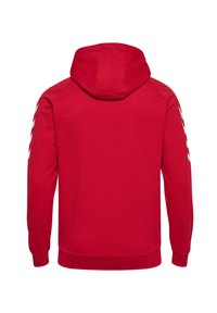 Felpa rossa con cappuccio regolabile, maniche lunghe e strisce diagonali bianche sulle spalle. Tessuto liscio con polsini e orlo a costine.