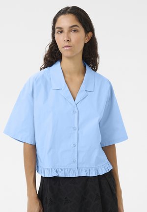 Light blue cropped shirt with a button-up front, short sleeves, and a ruffled hem, made from smooth fabric with a solid color.